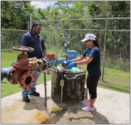 Photo of researchers on field sampling water from a well